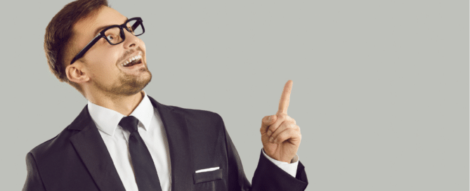 Businessman Thinks of a Good Business Idea, Points His Finger up and Smiles